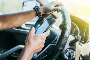 Person in his car using cell phone, Close up of driver hands using his phone, Concept driver hands touching cell phone screen photo