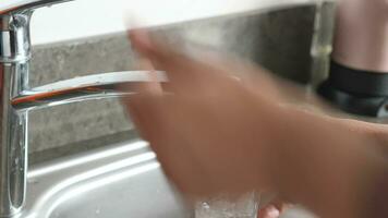 water pouring from a faucet tap in a glass, drinking pure water concept video