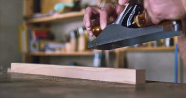 A carpenter works with a large hand plane and shows thin shavings. The video has high-quality sound