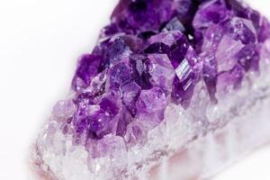 Macro mineral stone purple amethyst in crystals on a white background photo