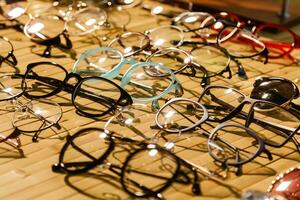 large selection of sunglasses and glasses on a stand photo