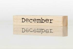 a wooden cube with an inscription December on a white background photo