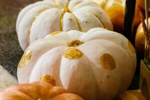 beautiful painted pumpkins of white and gold color on halloween photo