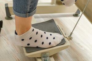 Female feet on the pedal of a sewing machine, motor photo