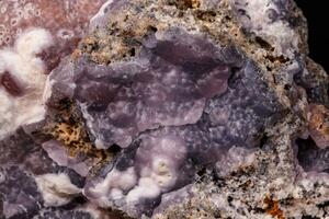 Macro pink Smithsonite mineral stone on microcline on black background photo