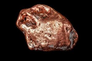 Macro mineral stone of a copper nugget on a microcline on a black background photo