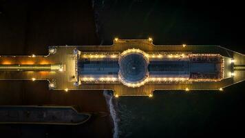 aéreo ver de Brighton muelle a noche con todas el colores viniendo afuera, este sussex, Reino Unido foto