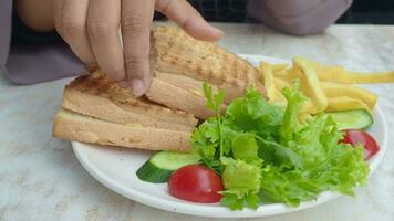 women hand pick Sandwich with ham, cheese, tomatoes,, video