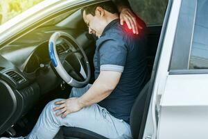 A car driver with muscle pain, concept of a man in his car with neck pain. An exhausted driver with back pain, A person with muscle pain in traffic photo