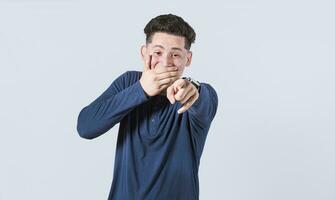 aislado atractivo chico riendo a tú, un hombre señalando a cámara con mano terminado boca, masculino haciendo divertido de usted foto