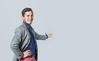 hombre señalando espalda y presentación un producto, hombre en un traje acogedor, hombre mirando a el cámara presentación un producto, persona atractivo foto