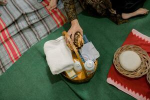 a woman is holding a basket of items on a blanket photo