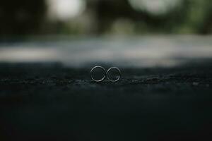 dos anillos sentado en el suelo en un oscuro habitación foto