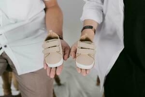 a man and woman holding their baby shoes photo