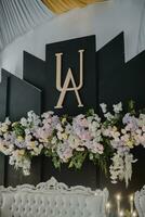 a wedding reception with a black backdrop and flowers photo