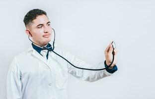 Male doctor holding stethoscope on white background. Portrait of latin doctor holding stethoscope with copy space photo