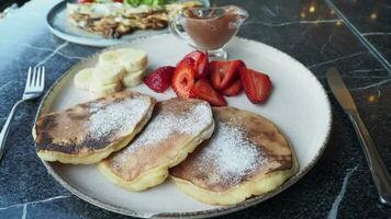 smakelijke maaltijd met bessen en pancake in kom op zwarte achtergrond video