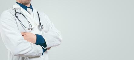 Banner of unrecognizable doctor with crossed arms with space for text. Crossed arms doctor medical banner photo