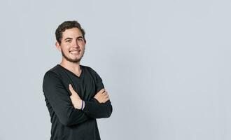 Happy handsome man with crossed arms, portrait of an attractive guy with crossed arms on isolated background, smiling person with crossed hands photo