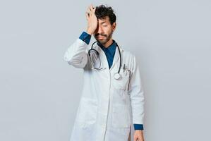 Tired doctor with hand on forehead, Exhausted doctor with hand on forehead isolated photo