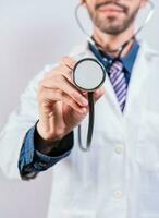 Unrecognizable doctor holding a stethoscope on white background. Close up of doctor holding stethoscope isolated photo