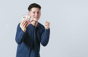 Excited man with money in his hand, astonished man with banknotes in his hand, concept of man earning money photo