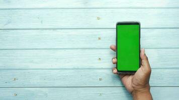 top view of young man hand using smart phone with green screen video