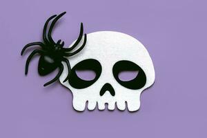 Halloween concept background. Top view of skull and Halloween decorative spider. Halloween party decoration concept photo