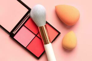 Top view of face powder blush palette, makeup sponges and makeup brush. Beauty and makeup concept photo