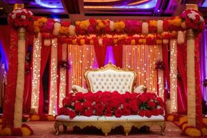 a red and gold wedding stage with a white chair and red flowers. AI-Generated photo