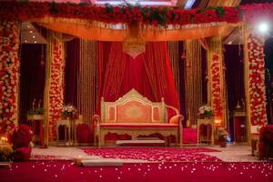an indian wedding stage decorated with red and gold. AI-Generated photo