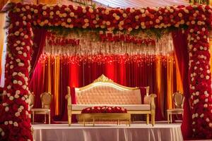 a wedding stage decorated with red and gold flowers. AI-Generated photo