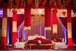 an indian wedding stage decorated with red and gold flowers. AI-Generated photo