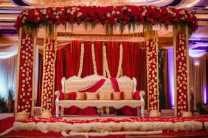 an indian wedding stage decorated with red and white flowers. AI-Generated photo