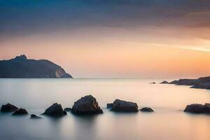 un largo exposición fotografía de rocas en el Oceano a puesta de sol. generado por ai foto