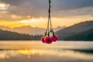 pink flowers hanging from a chain over a lake. AI-Generated photo