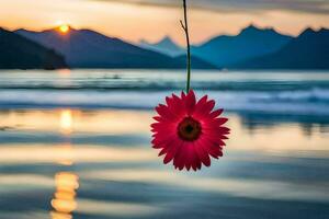 a red flower hanging from a string in front of a lake. AI-Generated photo