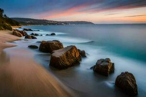 a long exposure photograph of rocks on the beach at sunset. AI-Generated photo