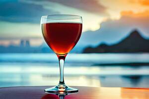 un vaso de rojo vino en un mesa en frente de el océano. generado por ai foto