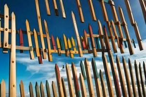 a fence made of wooden sticks with many different colored sticks. AI-Generated photo