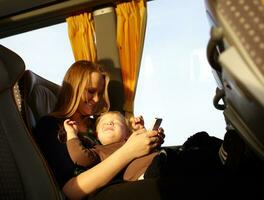 Mother and kid are playing game on the phone. photo