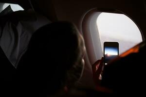 Woman taking photographs through a cabin porthole photo