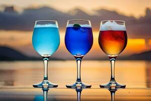 Tres lentes de de colores bebidas en un mesa con un puesta de sol en el antecedentes. generado por ai foto