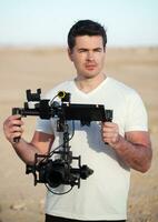 Videographer with steadicam equipment on the beach photo