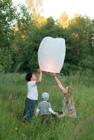 Family of three flying paper lantern outdoor photo