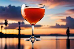 un vaso de naranja jugo en un mesa en frente de un puesta de sol. generado por ai foto