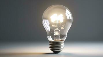 Glowing glass light bulb on grey background photo