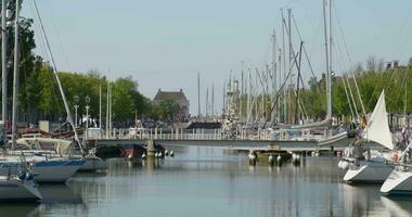 boats are docked in a canal near a bridge video