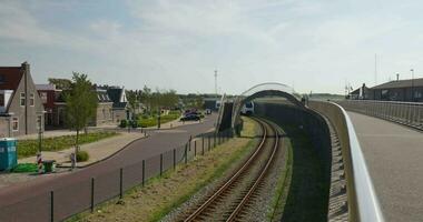 ein Zug gehen unter ein Brücke mit ein Auto auf das Spuren video