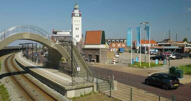 een trein gaan onder een brug met een auto Aan de sporen video